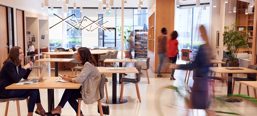 Personas trabajando y transitando en un local de oficina