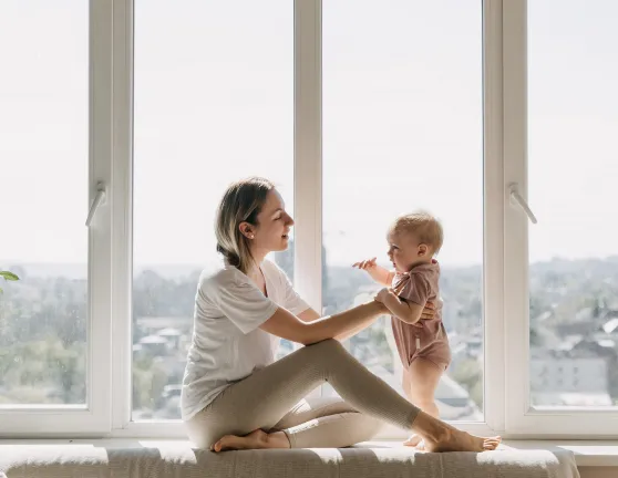 Madre poniendo de pie a su hijo en su casa