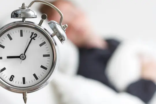 Reloj y persona descansando al fondo