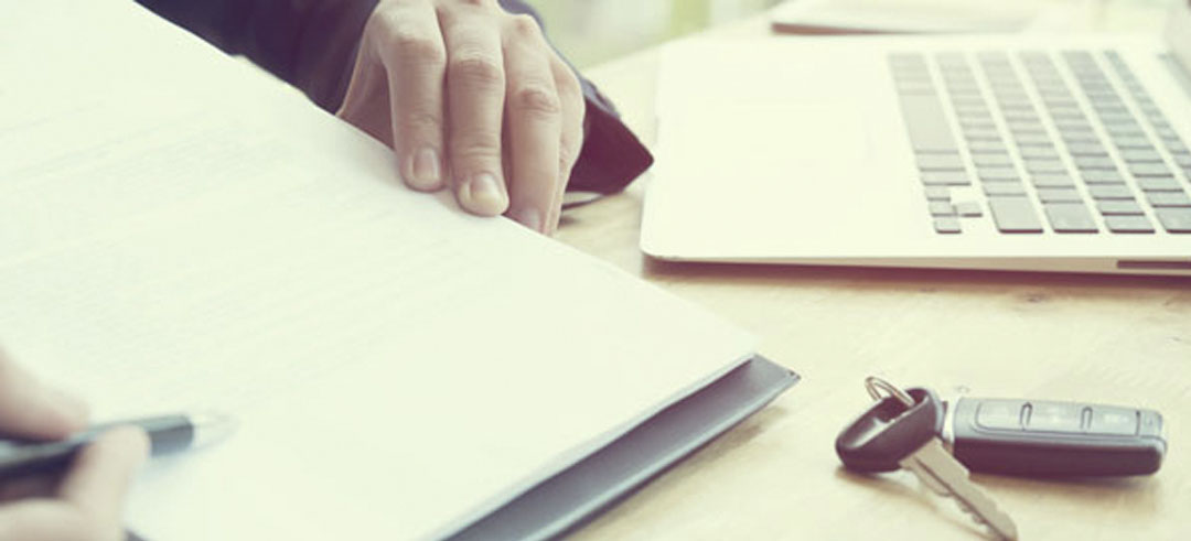 Persona firmando documentos para financiar un coche